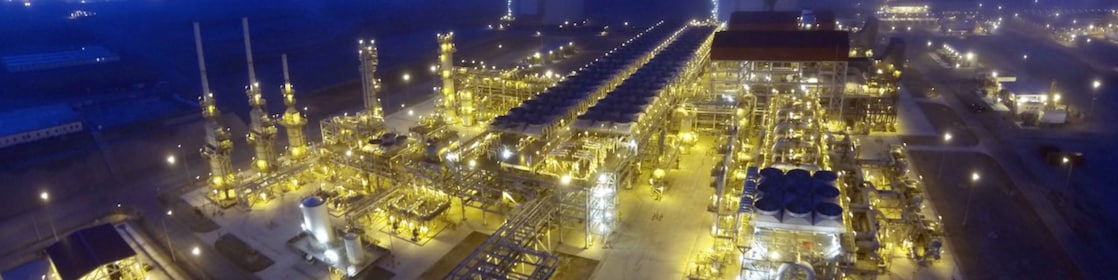 Vista aérea nocturna de una estructura completa de prospección petrolífera. Podemos ver varios almacenes y equipos típicos de esta zona.